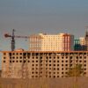 строительная площадка с недостроенным многоэтажным зданием и башенными кранами