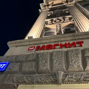 Светящаяся вывеска магазина Магнит на фасаде здания ночью