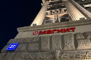 Светящаяся вывеска магазина Магнит на фасаде здания ночью