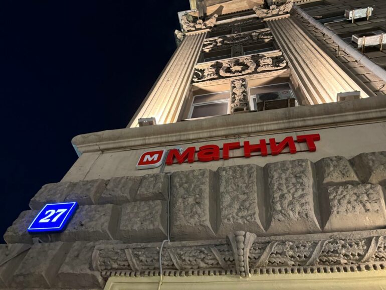 Светящаяся вывеска магазина Магнит на фасаде здания ночью